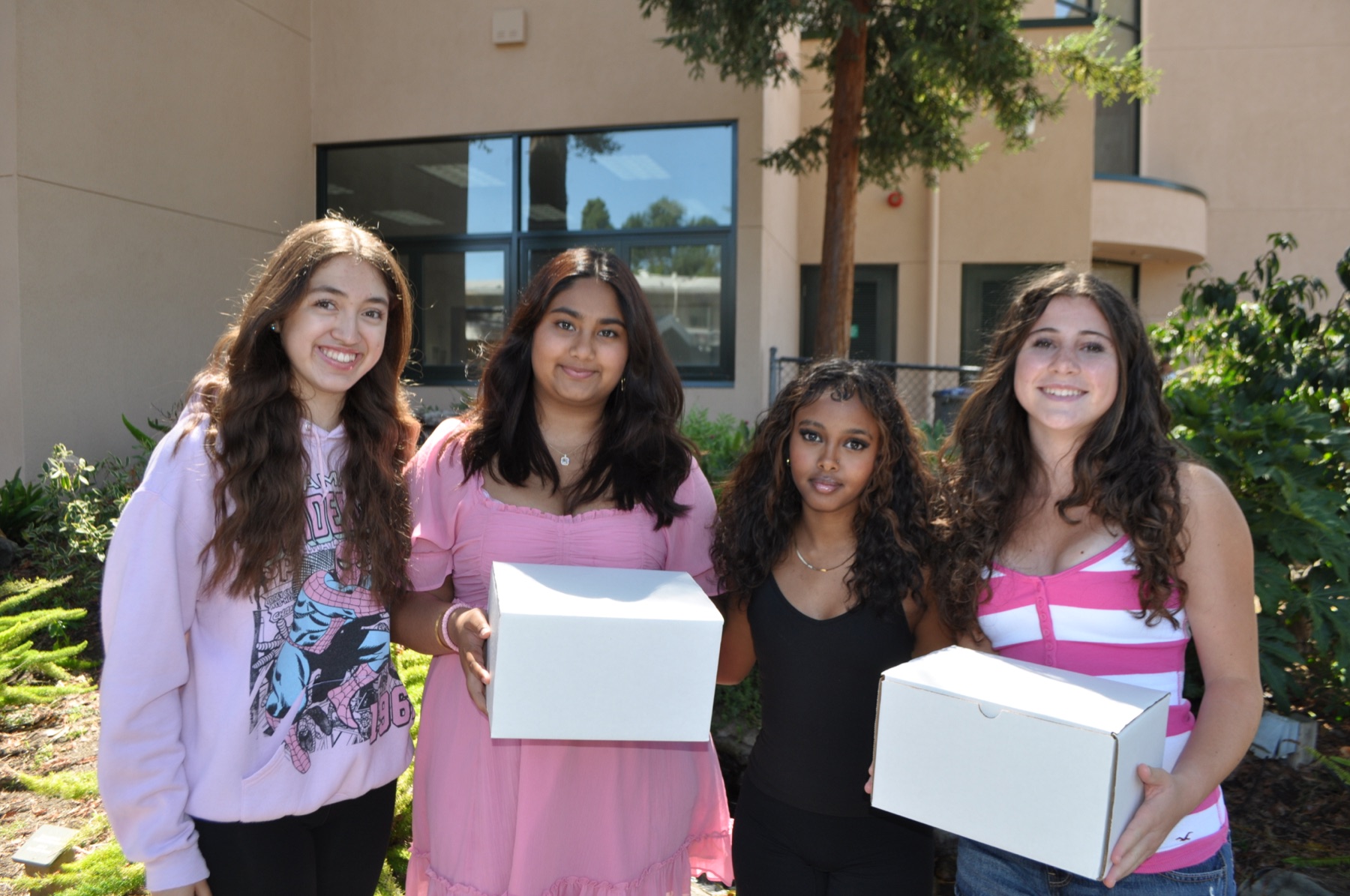 Four Pads for Peers team members holding Comfort Boxes outdoors